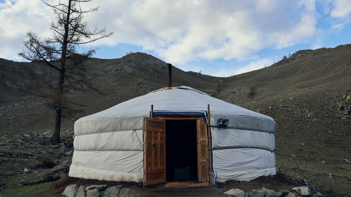 A Mongolian yurt in a scenic hilly landscape