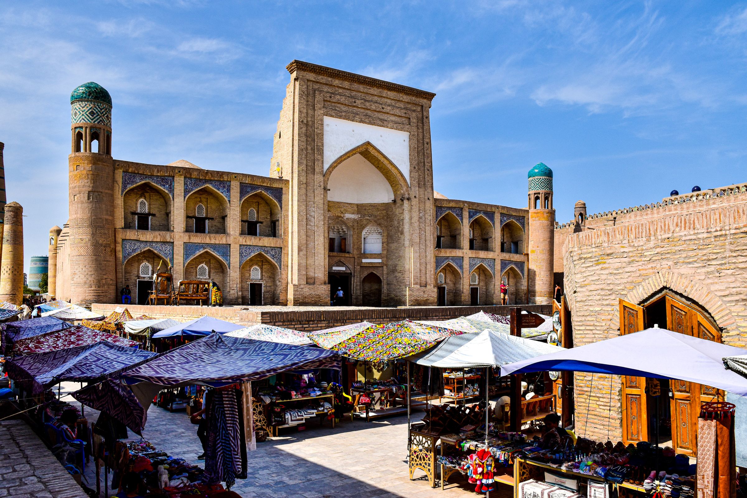 Open-air bazaar in front of historic buildings in Central Asia
